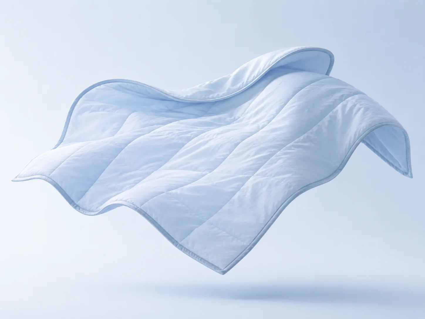 Light blue cooling comforter floating against a pale background.