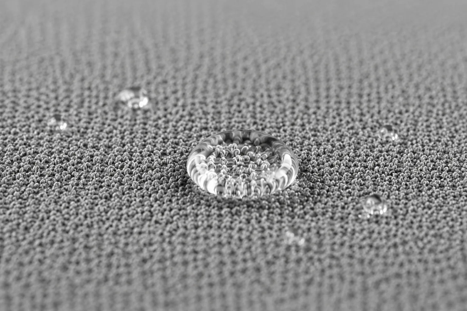 Fine grey textile surface with water-resistant droplets for pet-rest applications